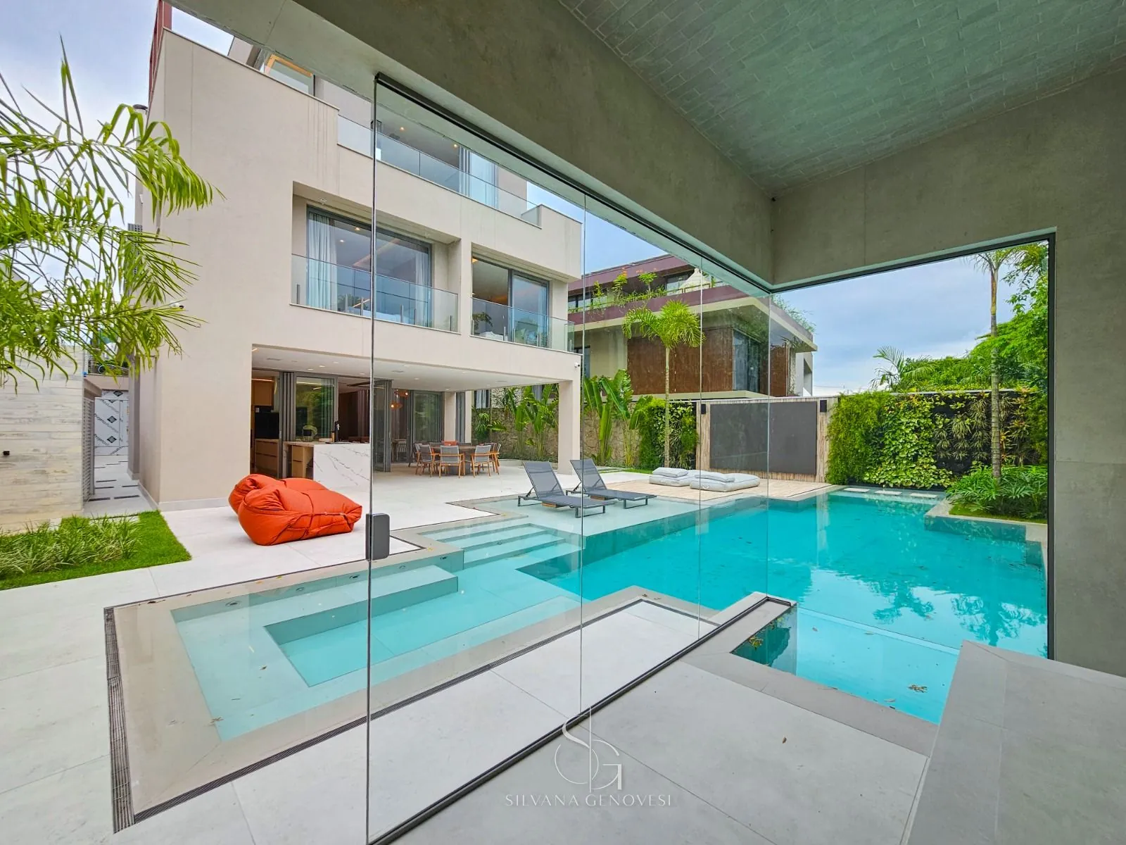 Área externa com piscina, pavilhão de vidro e jardim vertical